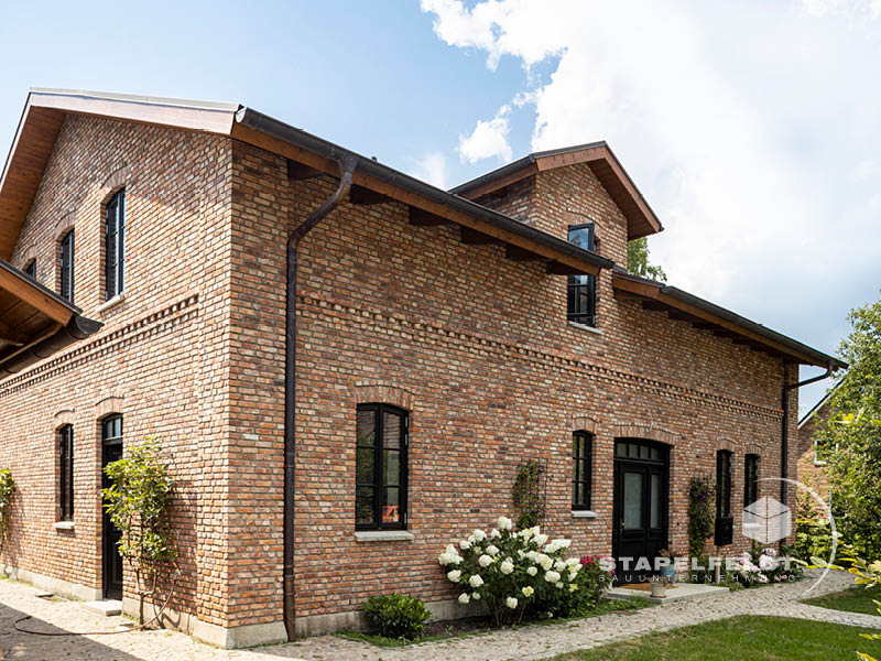 Haus bauen Bauunternehmen Hamburg Tatenberg Neubau Neubauvorhaben Hausbau Wohnhaus Industrial Style Einfamilienhaus Bruchstein Emden Granitsockel Verblendmauerwerk Rohbau Zierverbände Fassadenverblendung Stapelfeldt Bauunternehmung
