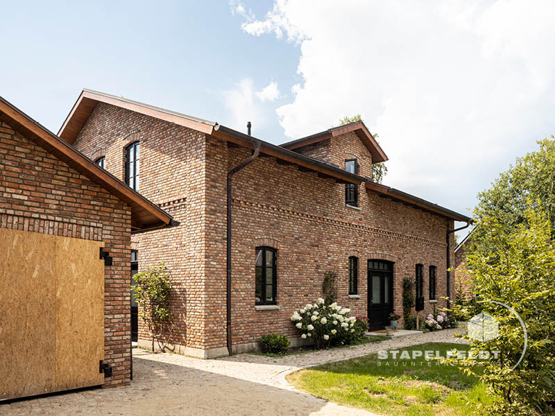 Haus bauen Bauunternehmen Hamburg Tatenberg Neubau Neubauvorhaben Hausbau Wohnhaus Industrial Style Einfamilienhaus Bruchstein Emden Granitsockel Verblendmauerwerk Rohbau Zierverbände Fassadenverblendung Stapelfeldt Bauunternehmung