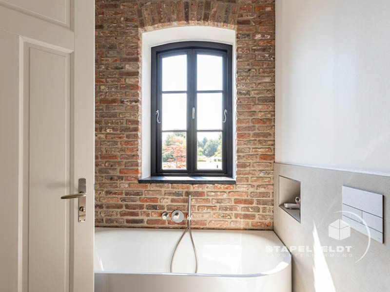 Haus bauen Bauunternehmen Hamburg Tatenberg Neubau Neubauvorhaben Hausbau Wohnhaus Industrial Style Einfamilienhaus Bruchstein Emden Granitsockel Verblendmauerwerk Rohbau Zierverbände Fassadenverblendung Stapelfeldt Bauunternehmung