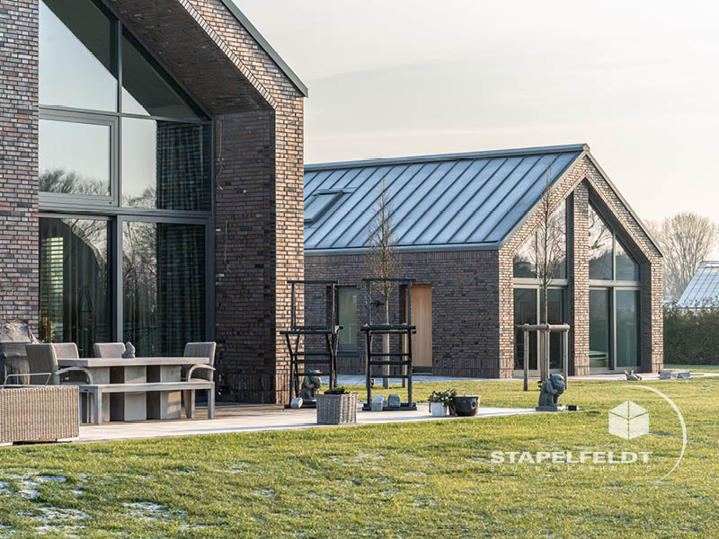Blick vom Haupthaus mit großer Glasfront zum Nebengebäude im Klinker in Hamburg-Curslack