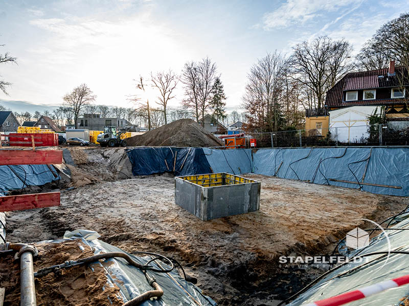 Baugrube mit Folienauskleidung und zentralem Betonbauteil im Quartier Reiherstieg | Bauunternehmen Stapelfeldt Bauunternehmung