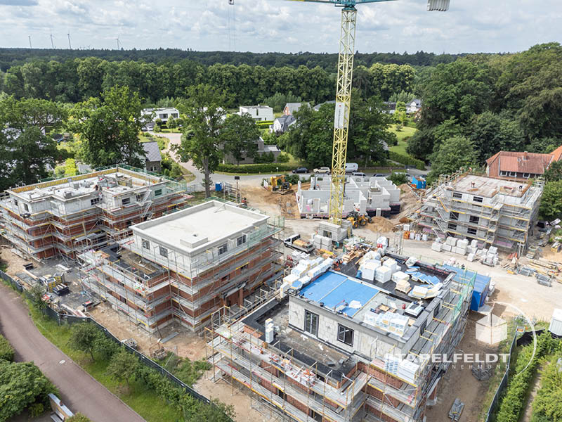 Luftaufnahme der Mehrfamilienhäuser im Wohnquartier Reiherstieg in Lüneburg mit Kran und Gerüsten.