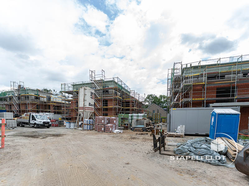 Baustelle im Wohnquartier Reiherstieg in Lüneburg mit Klinkerrohbauten, Gerüsten und Materiallager.