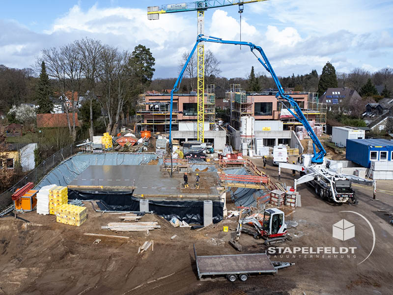 Überblick der Baugrube bei der Betonage im Wohnquartier Reiherstieg in Lüneburg mit Kran und Betonpumpe