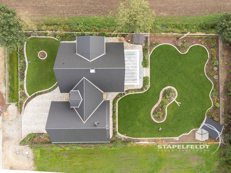 Luftaufnahme des Einfamilienhauses mit komplexer Dachlandschaft und Garten im Landkreis Lüneburg