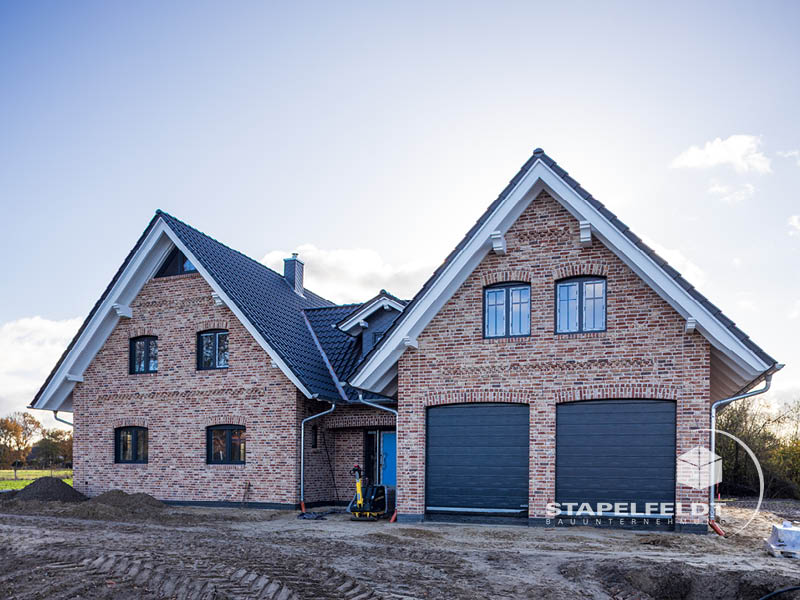 Eingangsseite mit zwei Garagentoren und Klinkerfassade | Bauunternehmen exklusives Einfamilienhaus Landkreis Lüneburg