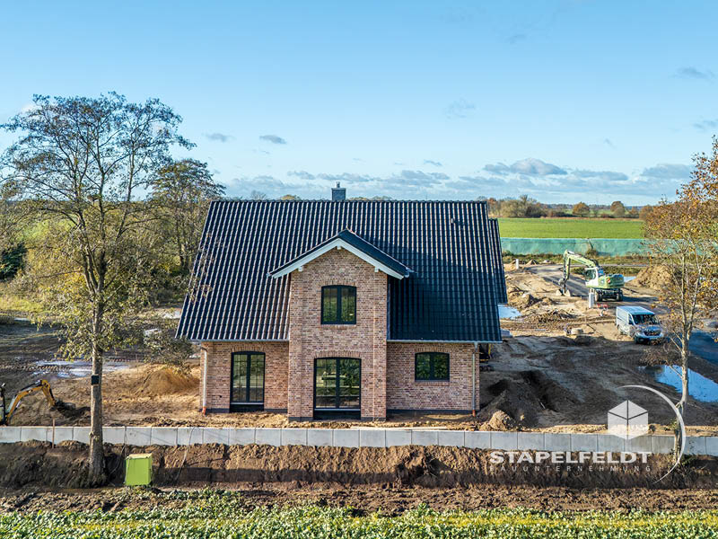 Frontansicht des Klinker-Einfamilienhauses mit Sprossenfenstern und Giebel | Bauunternehmen exklusives Einfamilienhaus Landkreis Lüneburg