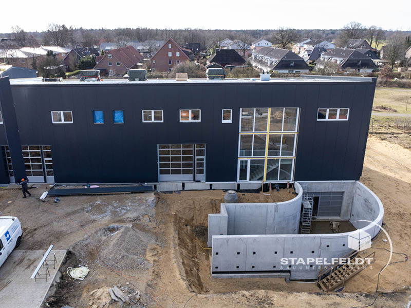 Frontansicht der fertigen Hallenfassade mit großen Toren und Glasfront, Hallenbau Norderstedt.