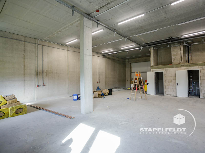 Innenraum der Gewerbehalle im Ausbau, Betonwände und Technikbereiche, Hallenbau Norderstedt.