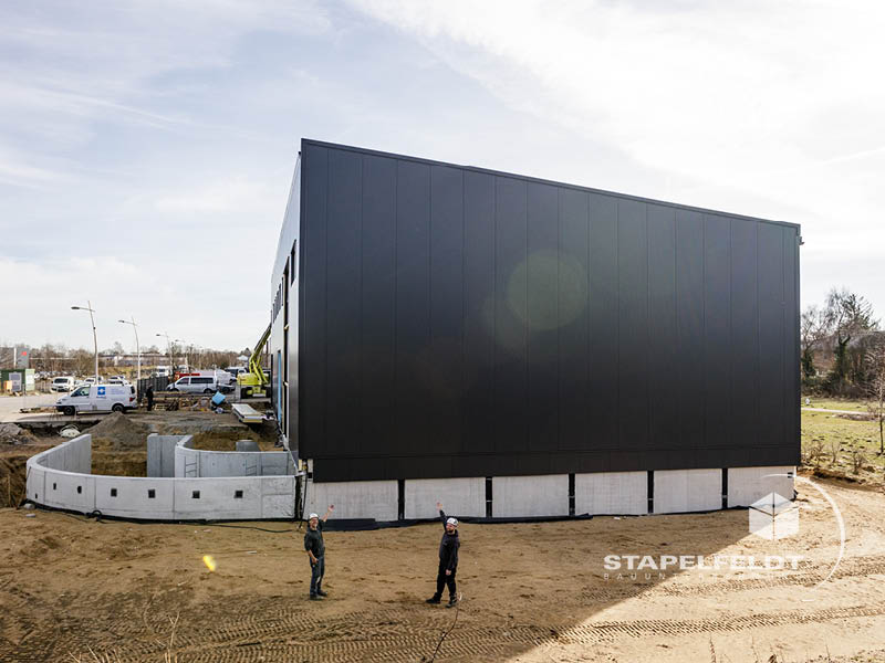 Außenansicht der fertigen Hallenrückseite mit Betonbauwerk davor, Hallenbau Norderstedt bei Hamburg.